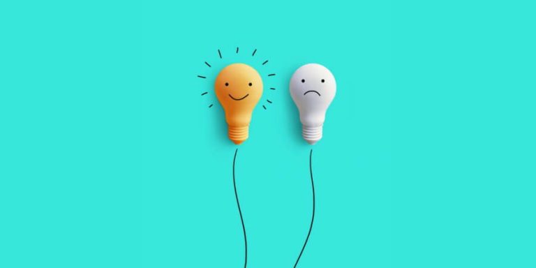 Imagem de duas lâmpadas com rostos desenhados (uma está feliz e a outra triste), representando a importância de criar valor para o cliente no Dia Mundial da Qualidade.
